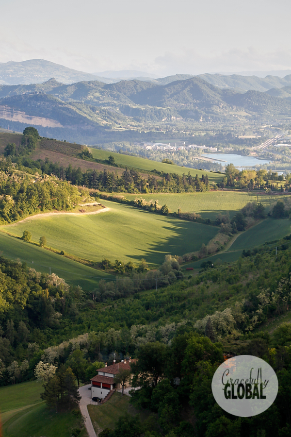 Rolling green hills dotted with trees and a distant lake are just outside Bologna's urban historic center.